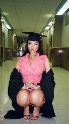 a woman sitting on the ground wearing a graduation cap and gown