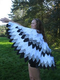 a woman is dressed up like an angel with black and white feathers on her wings