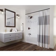 a bathroom with a sink, mirror and shower curtain in it's center area