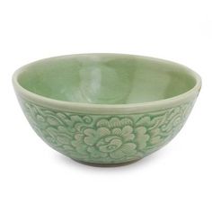 a green bowl sitting on top of a white table