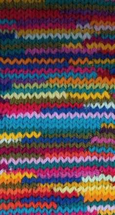 a multicolored knitted blanket with wavy lines