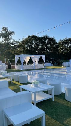 tables and chairs are set up in front of an empty swimming pool at a wedding reception