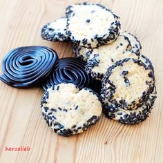 several cookies with black and white sprinkles sitting on a wooden table next to each other