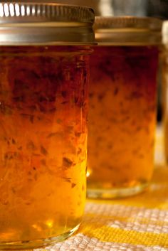 two jars filled with food sitting on top of a yellow and white checkered table cloth