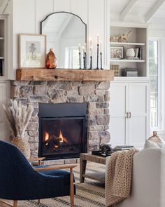 a living room filled with furniture and a fire place in front of a stone fireplace