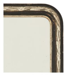 an ornate black and gold framed mirror against a white background with the reflection of it's image