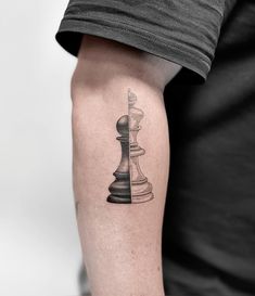 a black and white chess piece tattoo on the arm