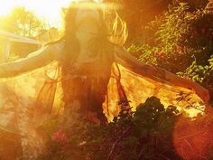 a woman with her arms spread out in the sun