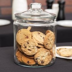 a glass jar filled with cookies on top of a table