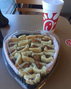 a heart shaped pie sitting on top of a table next to a cup