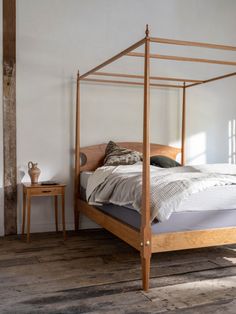 a bed sitting in the middle of a room next to a wooden table and chair