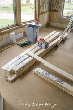 some wood is laying on the floor in front of a window with windowsills