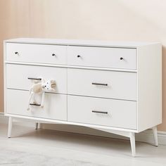 a white dresser with two stuffed animals on it