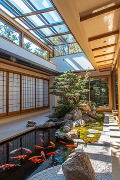 an indoor japanese garden with koi fish in the pond and rocks on the ground