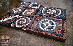 some kind of art made out of rocks and pebbles on the ground in front of a building