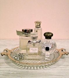 an assortment of perfume bottles on a glass tray