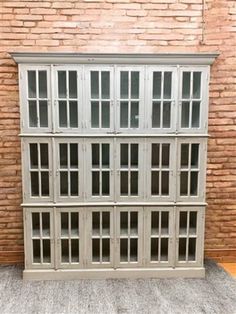 an old window is on display in front of a brick wall and carpeted floor