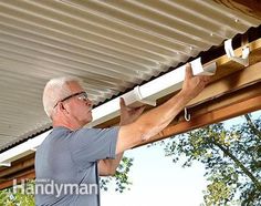 an older man is working on the gutter