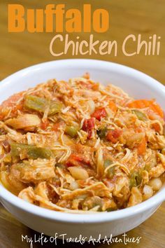 a white bowl filled with chicken chili on top of a wooden table