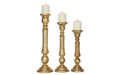 three gold candlesticks with one lit and the other turned off in different directions