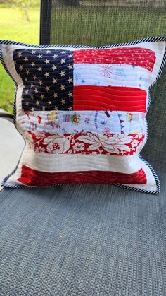 an american flag pillow sitting on top of a chair