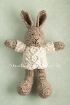 a knitted stuffed rabbit wearing a sweater