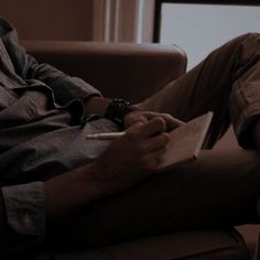 a man sitting in a chair holding a pen and paper