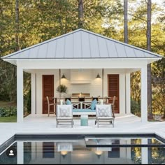 an outdoor dining area next to a pool in the middle of a wooded area with chairs and tables