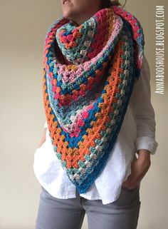 a woman wearing a multicolored crocheted scarf