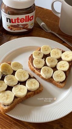 two pieces of bread with peanut butter and banana slices on them sitting on a plate next to a jar of nutella