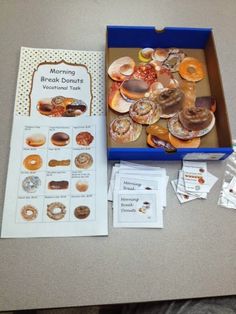 a box filled with lots of donuts on top of a table next to other items