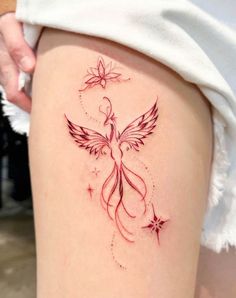 a woman's thigh with a tattoo design on the back of her leg, which is decorated with stars and a bird