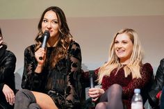 three women sitting on a couch talking into microphones