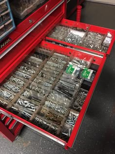 a red drawer filled with lots of screws and nails