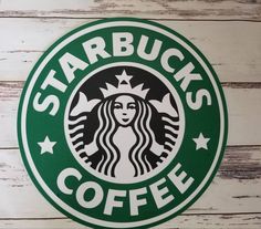 the starbucks logo is on top of a white wooden wall and has green lettering that reads starbucks's coffee