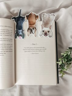 an open book with stickers on the pages and three dogs in different colors sitting next to each other