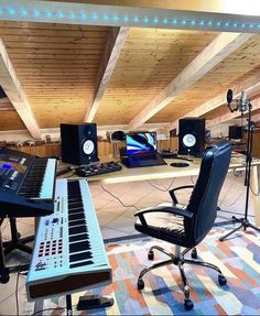 a recording studio with multiple monitors and keyboards