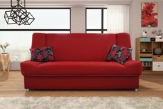 a living room with a red couch and large windows