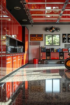 a motorcycle is parked in the middle of a room with red cabinets and counter tops