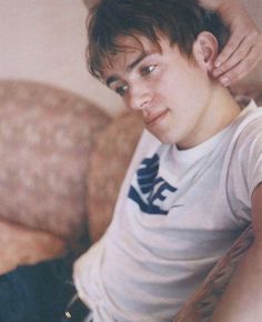 a young man sitting on top of a couch