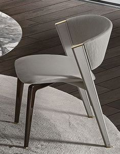 a modern dining chair with an upholstered seat and back rests on a white rug