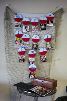 a bulletin board with pictures on it next to a chair and table in front of a net