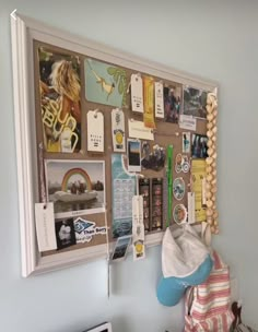 a bulletin board with pictures, magnets and other things hanging on it's wall