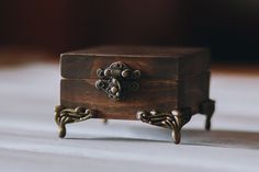 a small wooden box sitting on top of a white table next to a metal object