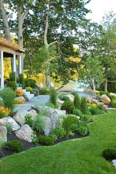 a garden with rocks, grass and trees