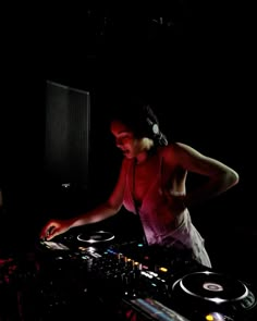 a woman dj mixing music in the dark