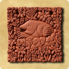 an intricately carved tile with flowers and fish