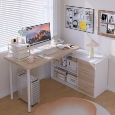 a desk with a computer on top of it in front of a window covered by blinds