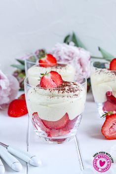 three desserts with strawberries and whipped cream in them are sitting on a table