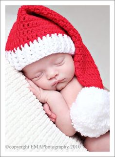 a newborn baby wearing a santa hat and sleeping on top of it's belly